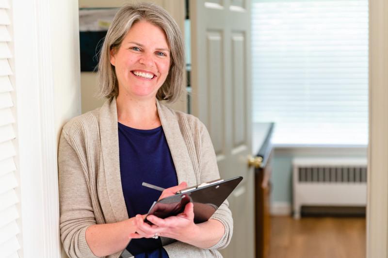 a provider with a clipboard smiling warmly