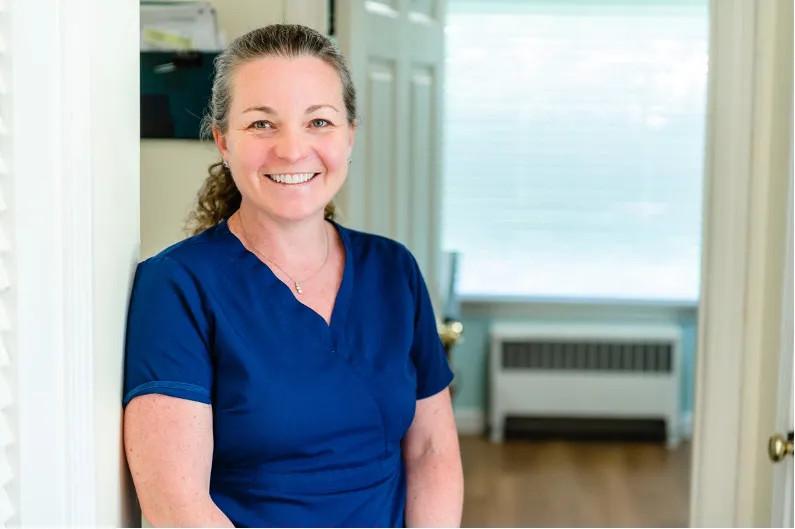a female provider smiling in a doorway