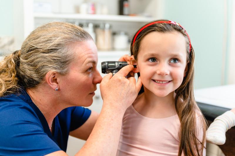 a provider examining the ear of a young girl