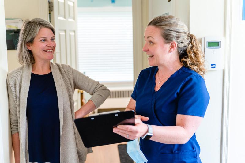two women talking to each other with a clipboard